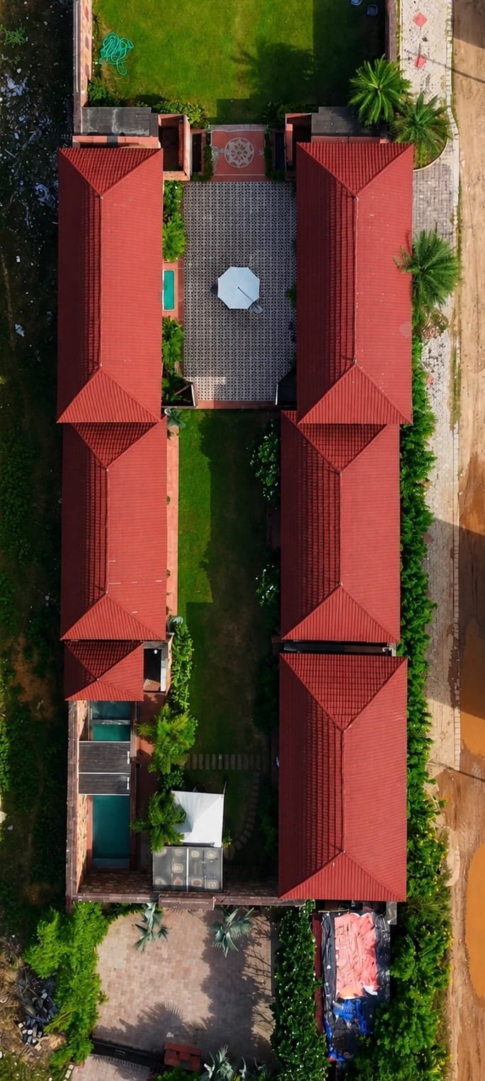 Aerial view of the estate: red-roofed stone villas around central lawns