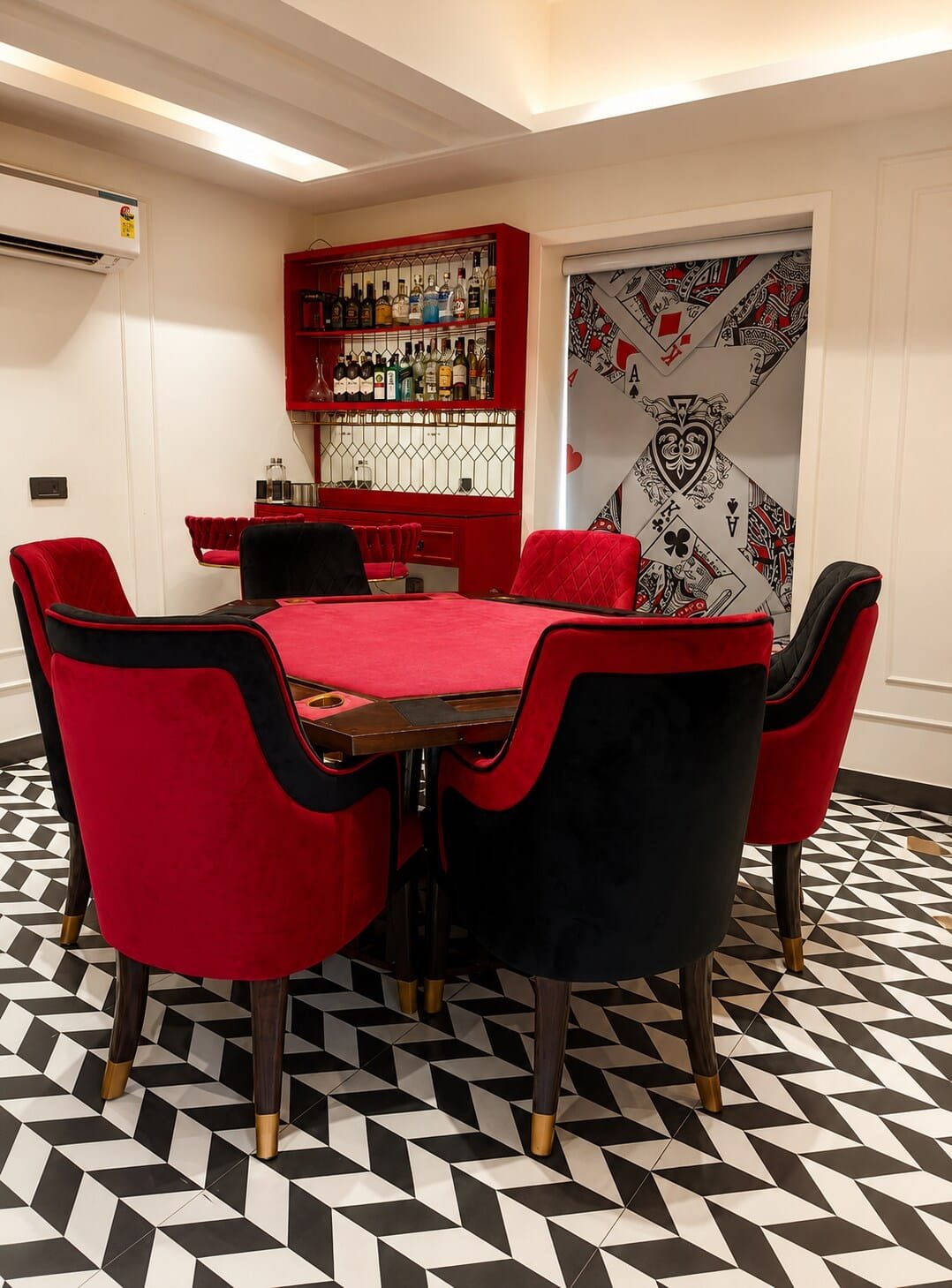 Poker table ringed by red and black velvet chairs