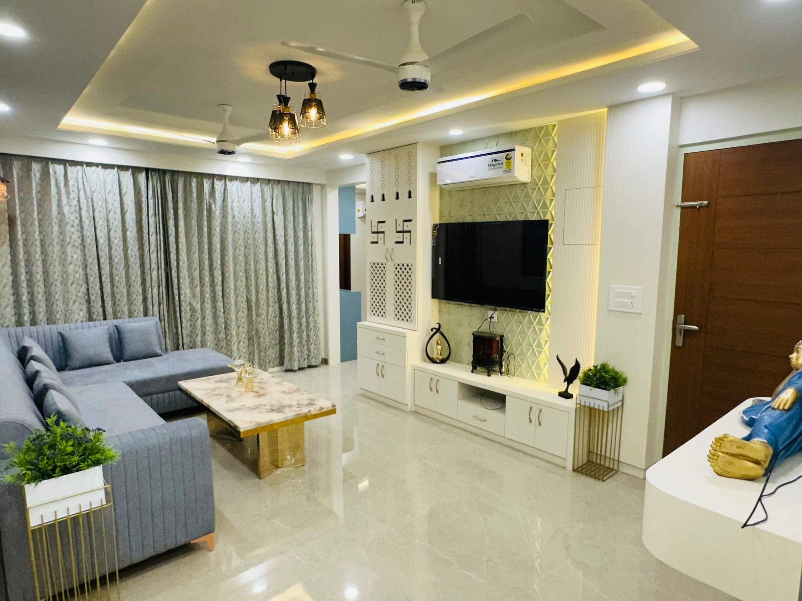 Open living area with a white TV console, grey sofa and ceiling pendant