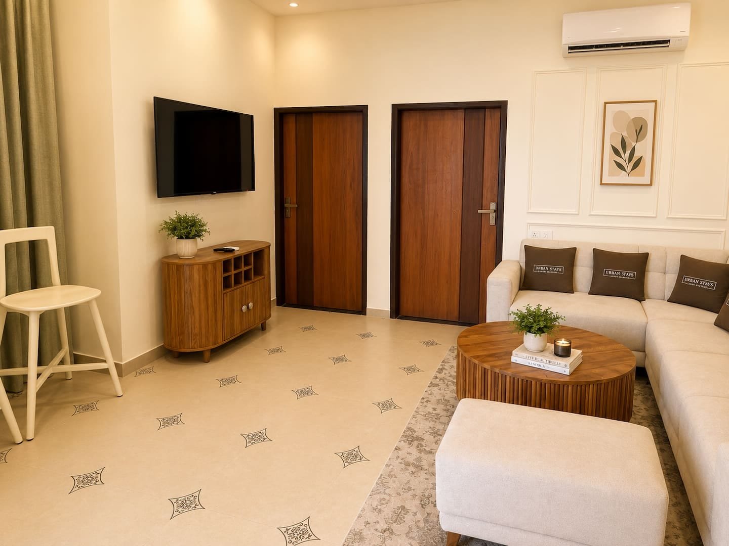 Living room with a wall-mounted TV, wooden sideboard and sofa, with doors to the bedrooms