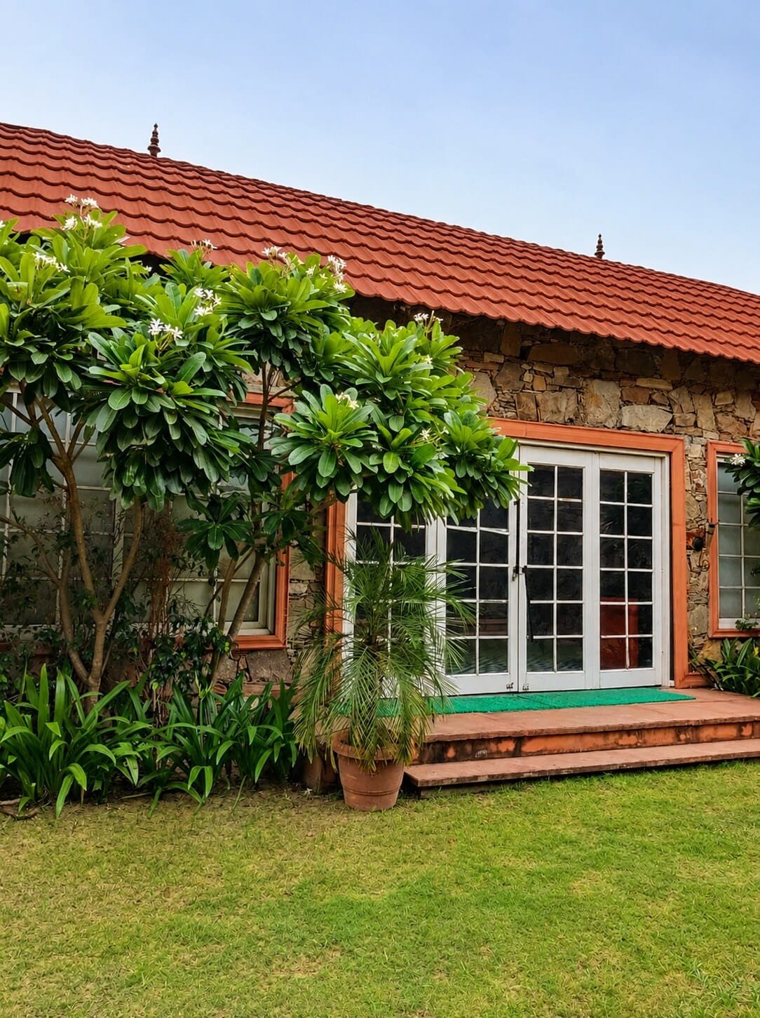 Villa verandah with French windows opening onto the lawn