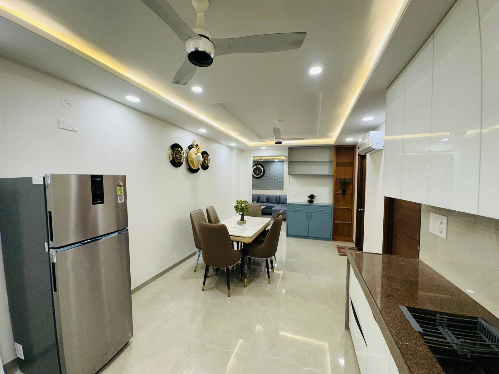 Open kitchen with a steel fridge leading to the dining area
