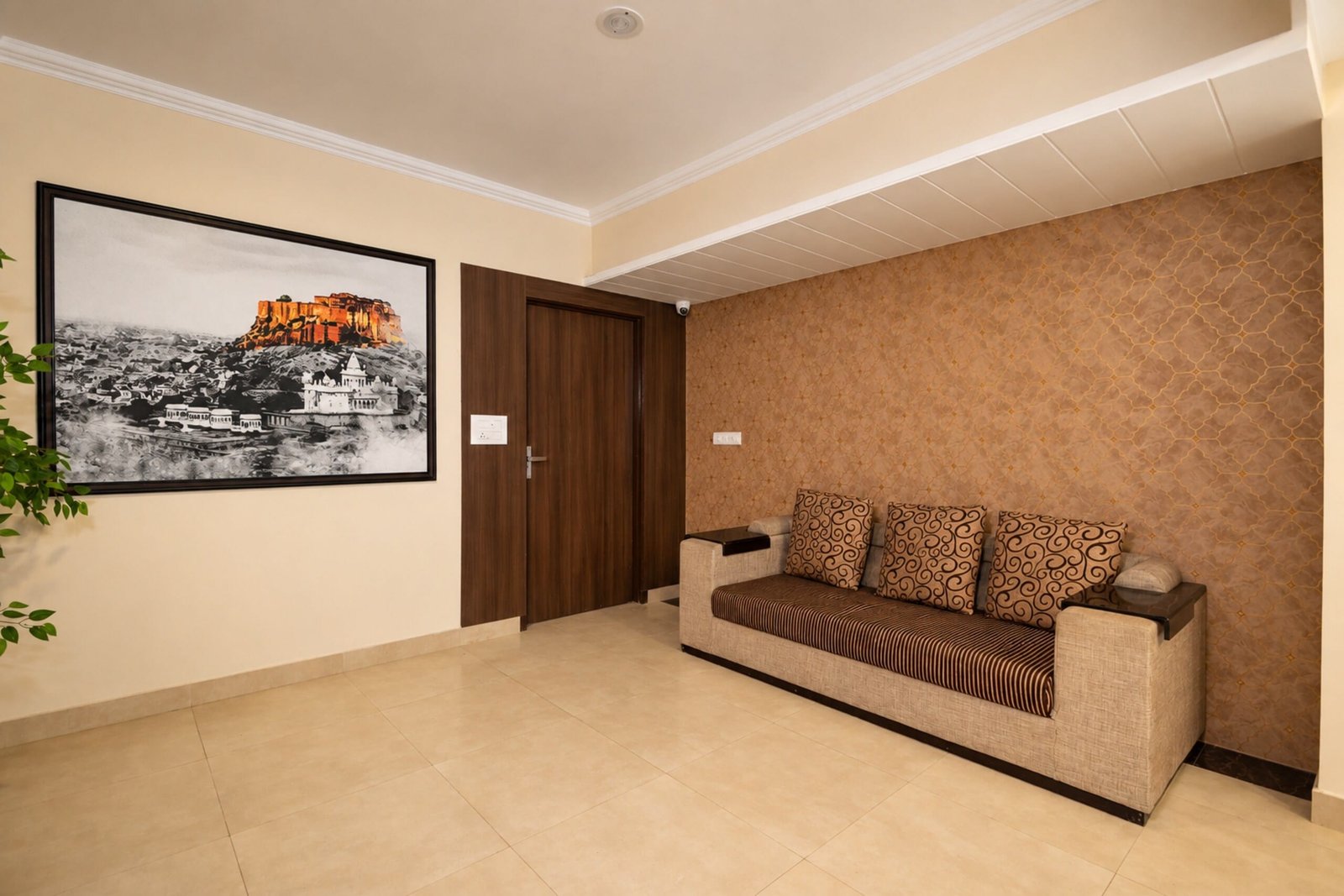 Lounge with a long sofa and a large black-and-white print of a Rajasthan fort