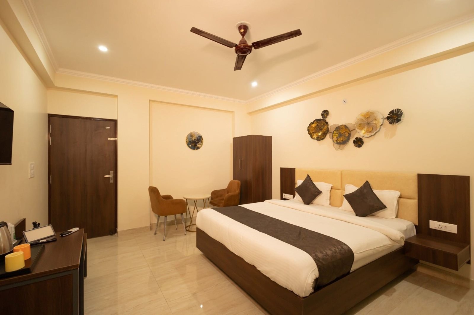 Guest room with a king bed, a wardrobe and a seating corner under a ceiling fan