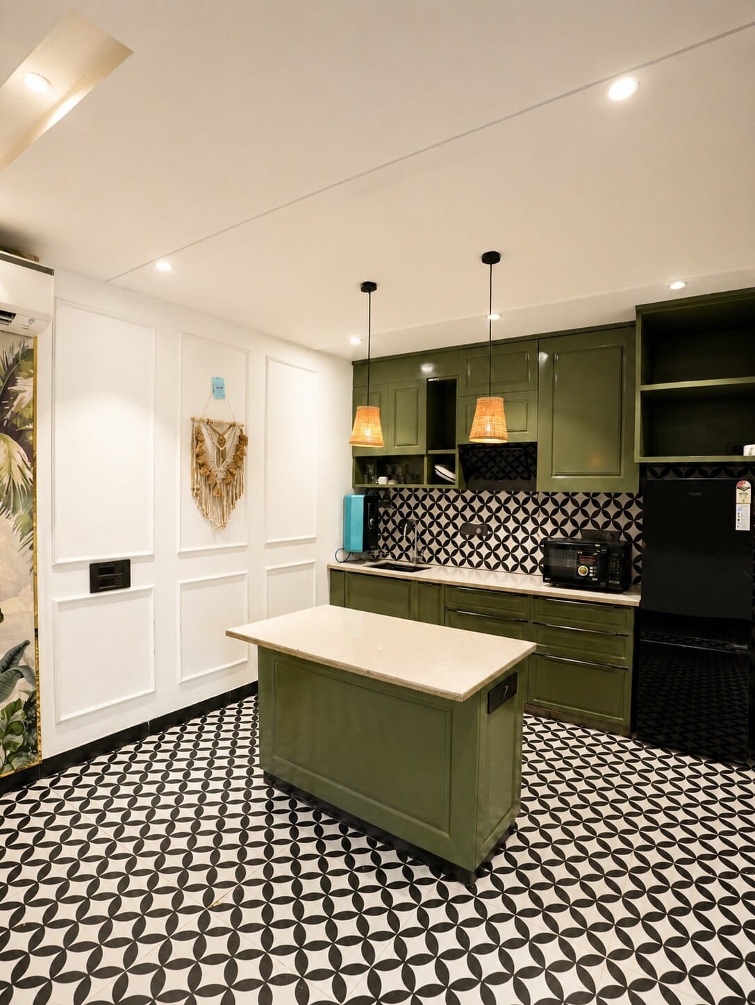 Kitchen with olive green cabinets, an island and pendant lights