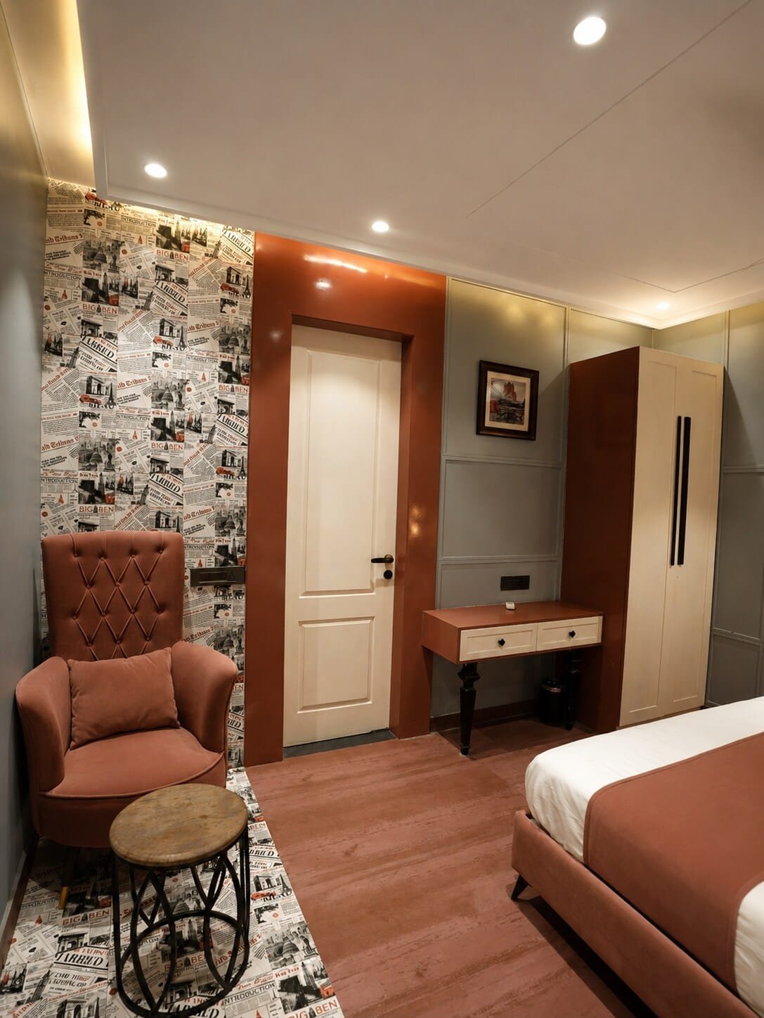 Bedroom 1 with terracotta armchairs, a desk and patterned wallpaper