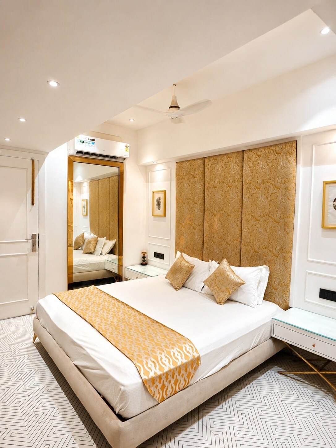 Bedroom with a gold-patterned headboard panel and full-length mirror