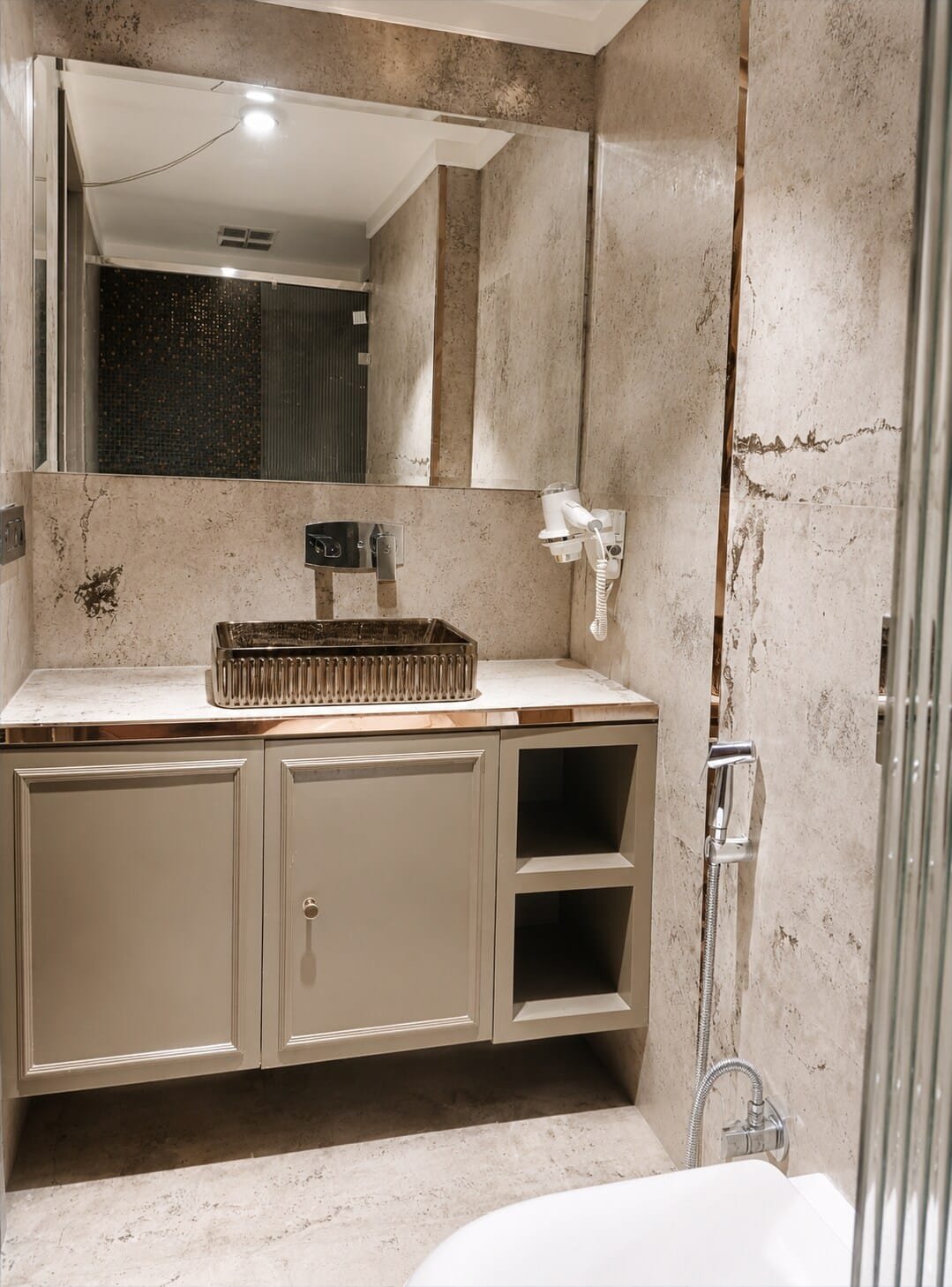 Bathroom with a stone vessel basin and grey marble walls