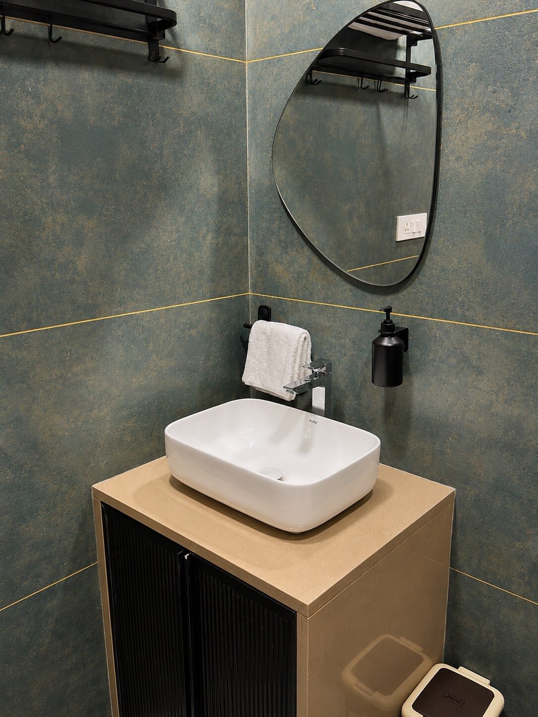 Bathroom with a vessel basin on a wooden vanity and teal patterned tiles