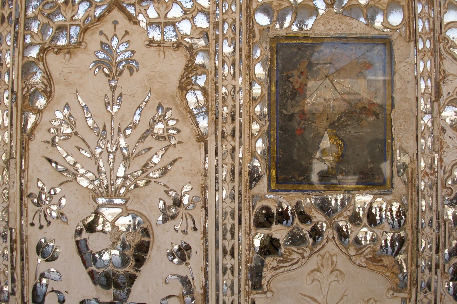 Mirror mosaic and carved flowers on a wall of the Sheesh Mahal