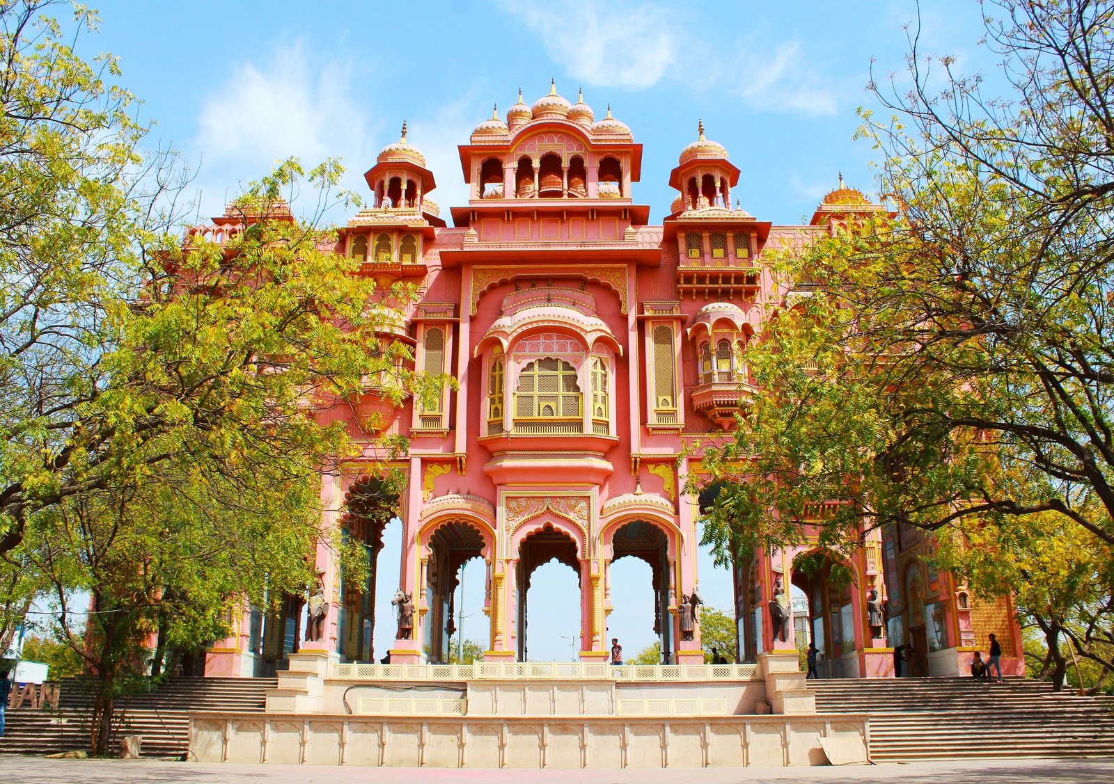 The painted pink gateway of Patrika Gate among trees